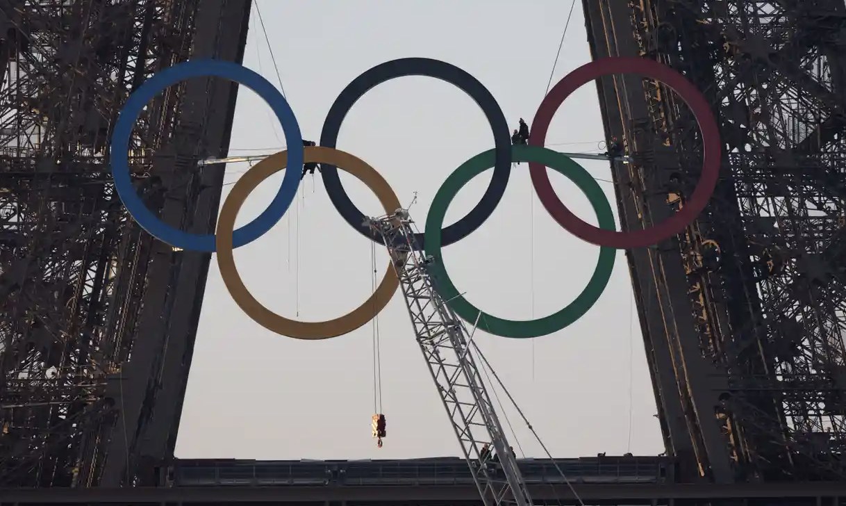 奥运五环的雕塑被吊在埃菲尔铁塔上